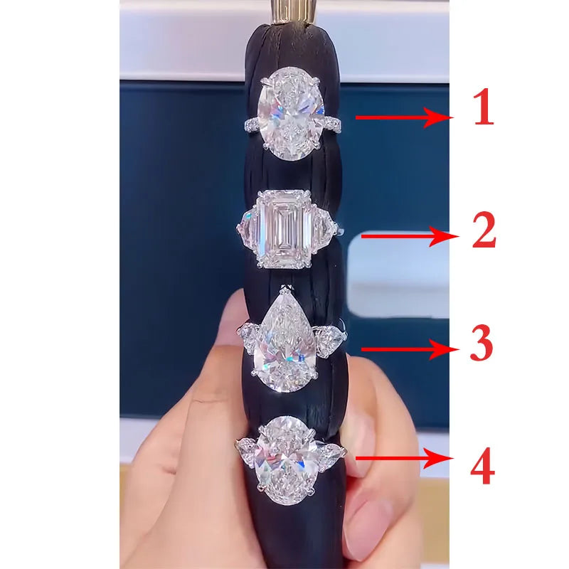 Diamond ring with four different diamond shapes held by a hand against a blurred background.