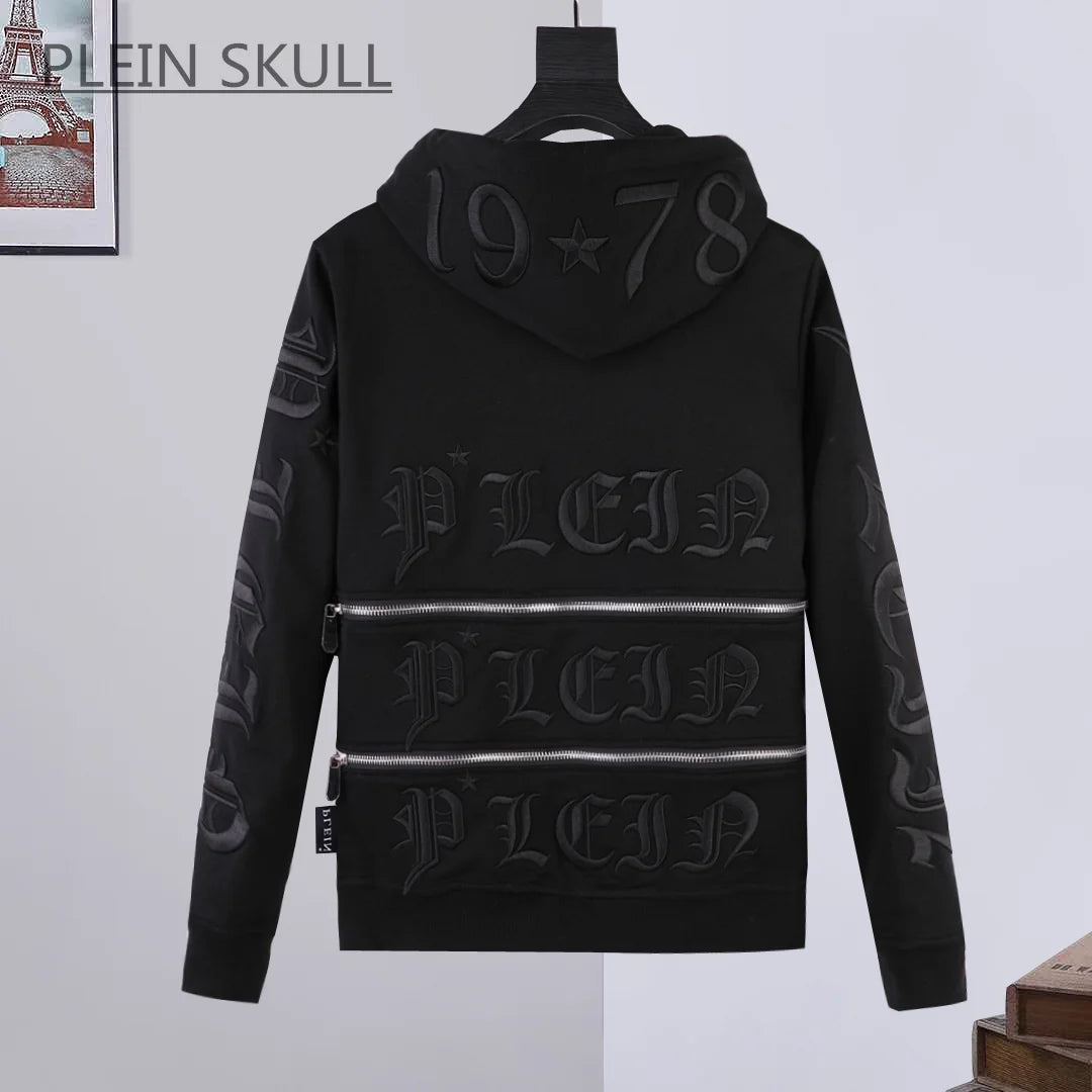 Black hooded sweatshirt with embossed gothic lettering and zipper details, displayed on a hanger against a light gray wall. The brand name 'PLEIN SKULL' is visible at the top left.
