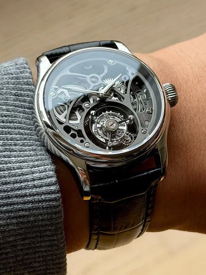 Luxury watch with transparent face on a wrist against a neutral background