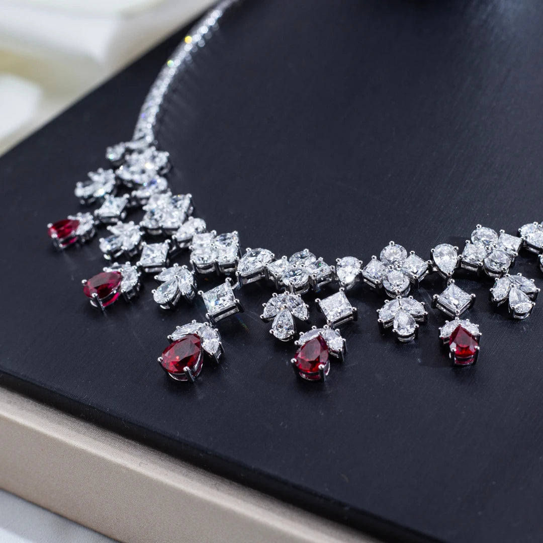 Jewelry set with red gemstones and silver accents on a dark surface