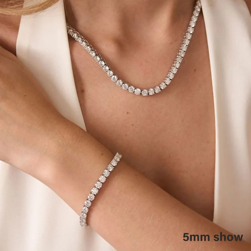 Diamond necklace and bracelet on a person wearing a white outfit