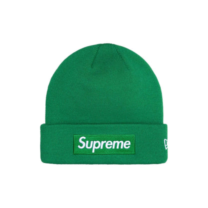 A green ribbed knit beanie hat featuring a white Supreme box logo patch on the front cuff and a small white New Era flag logo on the side, set against a plain white background.