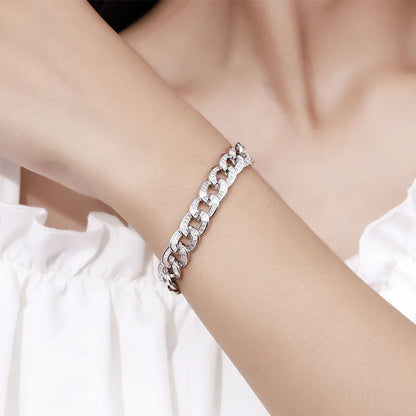 Silver chain bracelet on a person's wrist with a blurred background
