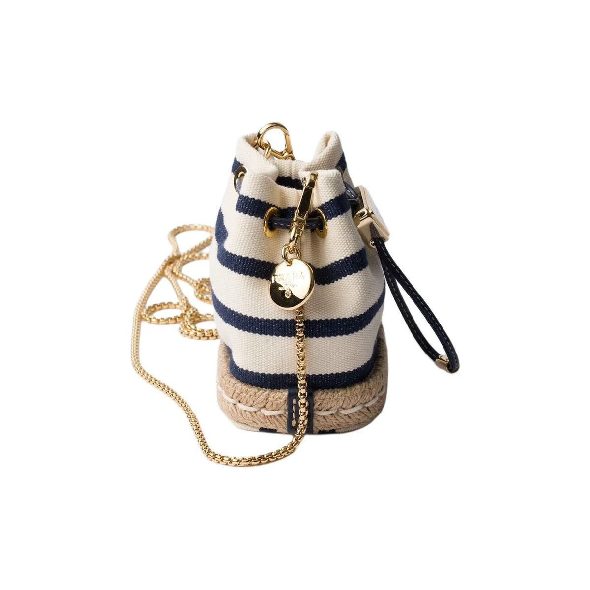 A small bucket-style espadrille bag with navy blue and cream horizontal stripes, a braided jute base, a gold-tone chain strap, and a dangling gold-tone charm on a plain white background.