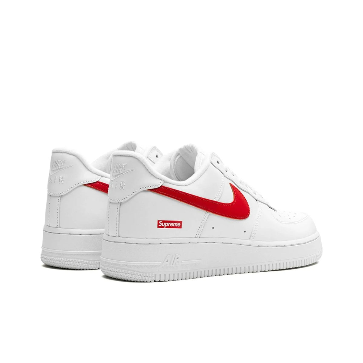 White Nike Air Force 1 Low sneakers with a red Supreme Swoosh and a red Supreme box logo on the side, shown against a plain white background.