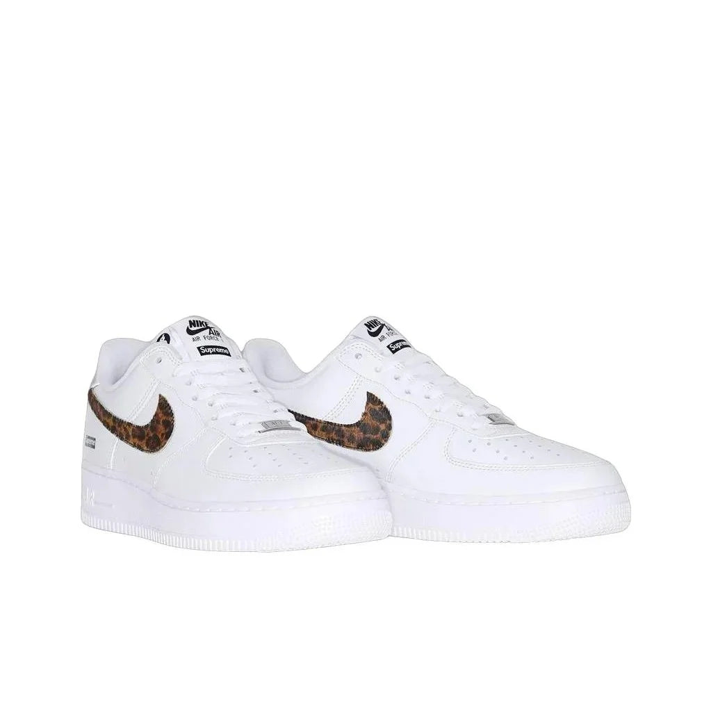 A pair of white Nike Air Force 1 Low sneakers with brown and black leopard print Swooshes, shown against a plain white background.