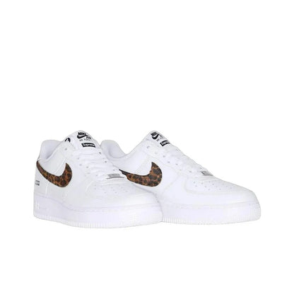 A pair of white Nike Air Force 1 Low sneakers with brown and black leopard print Swooshes, shown against a plain white background.